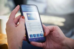 persona con telefono in mano guarda l'app della banca