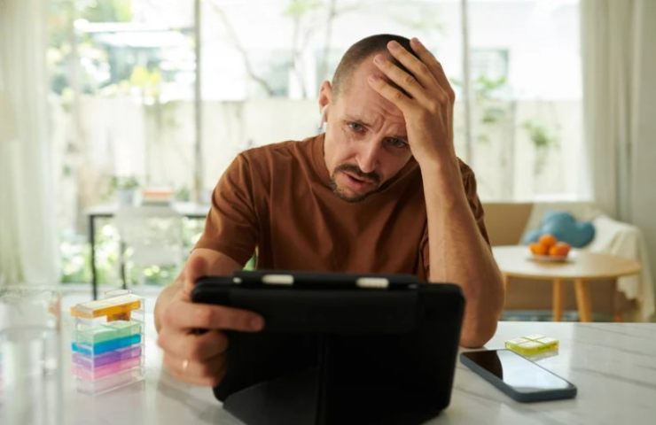 Uomo con le mani tra i capelli controlla la bolletta