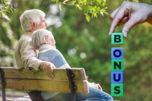 Anziani felici sulla panchina con scritta bonus