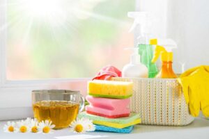 Tazza di camomilla con utensili per la pulizia della casa