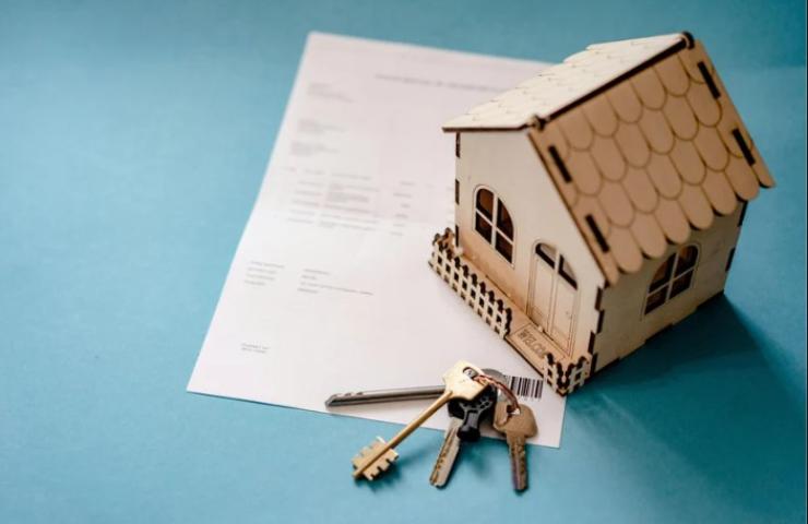 contratto affitto con un modellino di una casa e delle chiavi