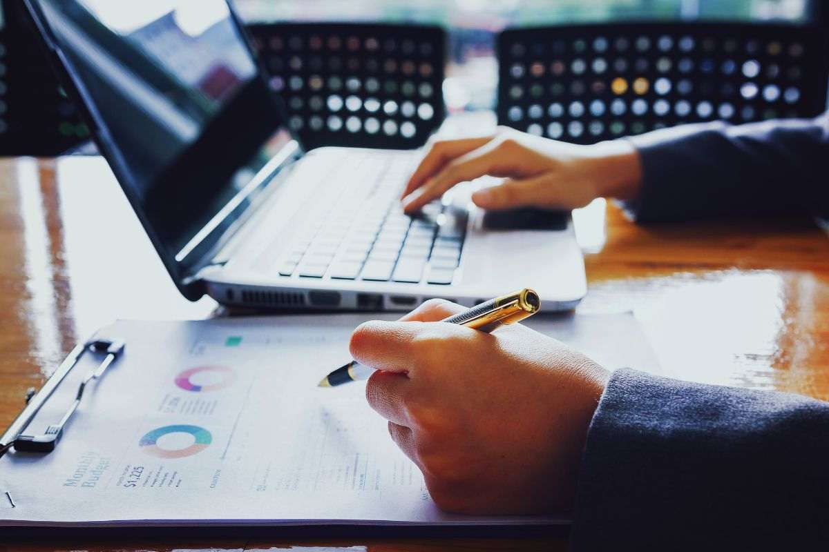 Uomo che prende appunti mentre lavora al PC