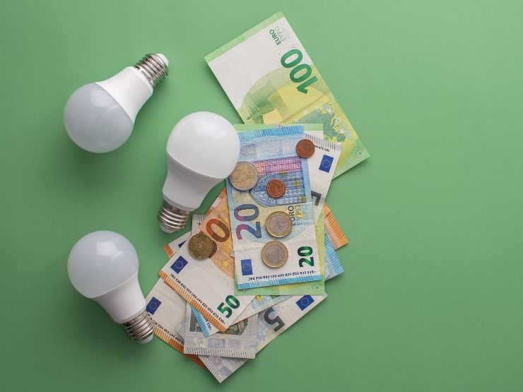 soldi euro e lampadine sul tavolo