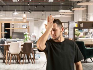 uomo dentro uno show room di mobili che si rende conto di aver commesso uno sbaglio
