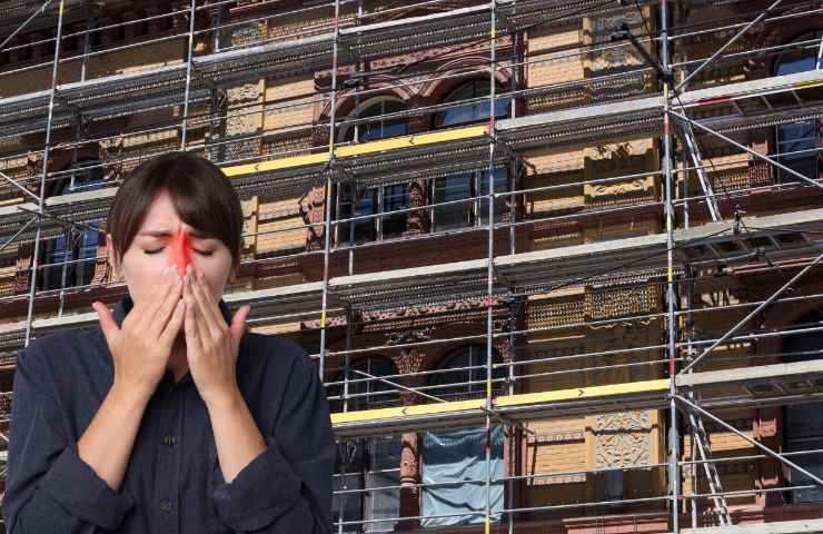 Donna allergica, sullo sfondo un palazzo con dei ponteggi installati per il rifacimento della facciata 