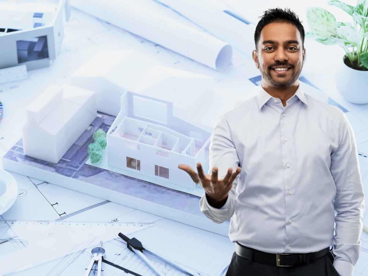 progetto di una casa sullo sfondo e uomo indiano in primo piano