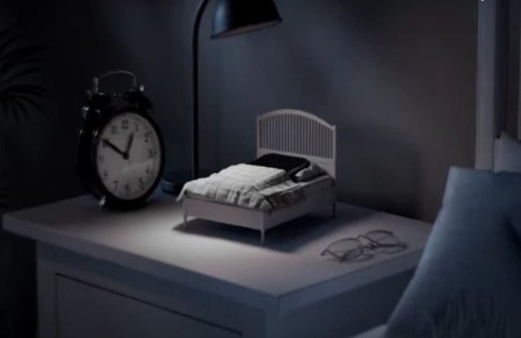 Mini letto sul comodino con uno smartphone all'interno