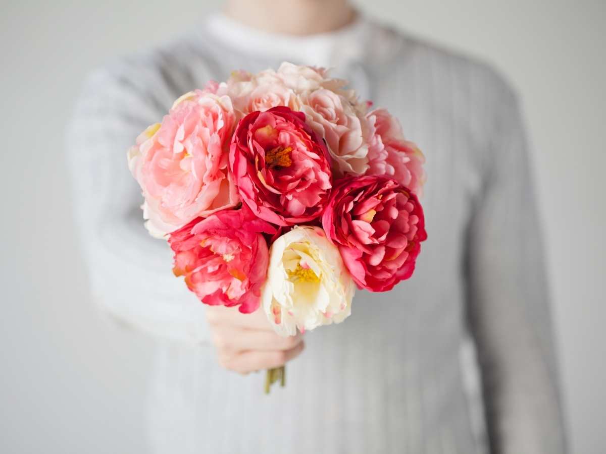 persona che regala mazzo di fiori