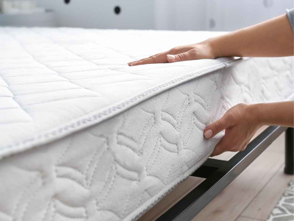 primo piano di una donna che solleva il materasso del letto