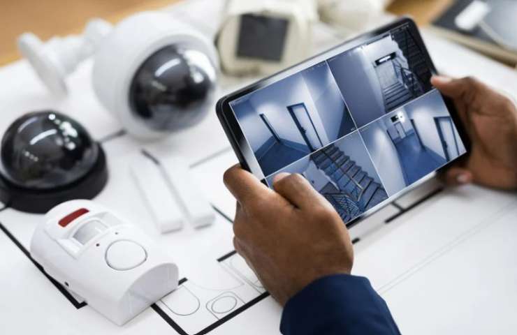 persona controlla con un tablet le telecamere di sorveglianza della propria abitazione