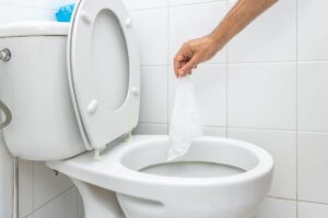 persona che getta salviettina nel wc