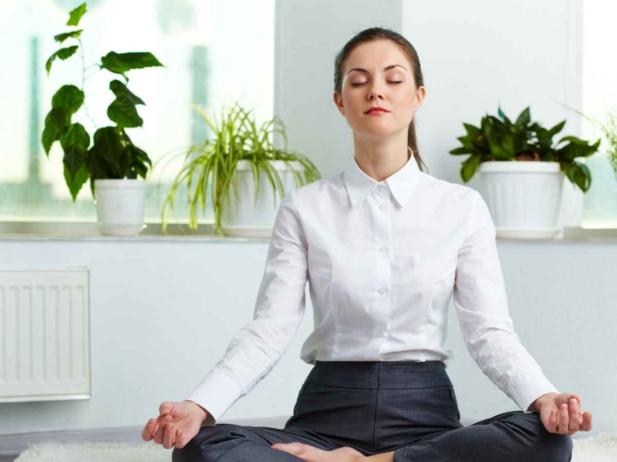 donna che si rilassa in casa, piante in vaso dietro di lei