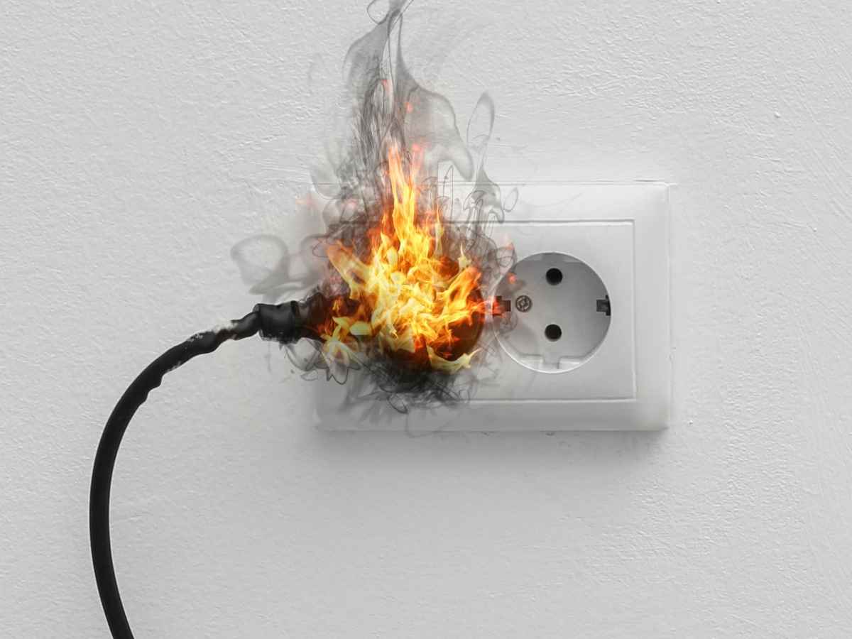 spina nella presa elettrica avvolta dalle fiamme