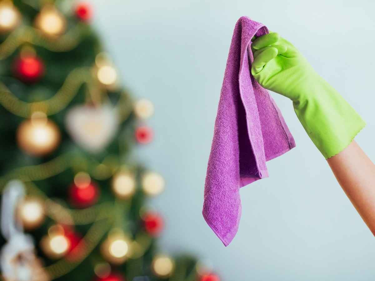 sfondo albero di natale in primo piano mano con panno pulizia