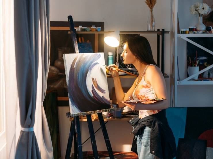 donna che dipinge un quadro nella sua sala hobby