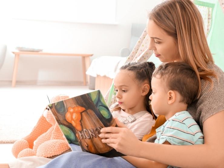 donna che intrattiene bambini con la lettura di un libro