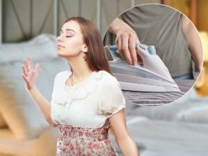 sfondo letto, in primo piano donna che annusa e ferro da stiro