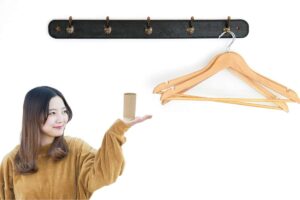 Ragazza che tiene in mano un rotolo di carta igienica e appendiabiti