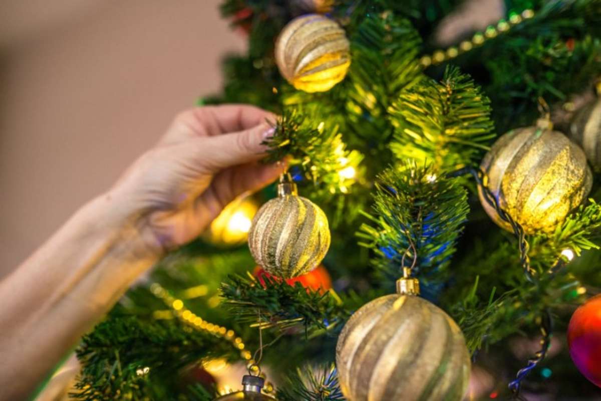 persona addobba l'albero di natale