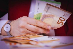 Persona che tiene in mano banconote