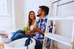 Coppia che scherza all'interno di una stanza in ristrutturazione