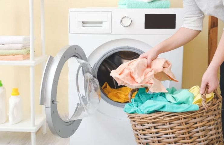 Persona mette il bucato in lavatrice