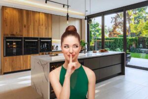 Donna che fa il gesto del silenzio all'interno di una cucina moderna