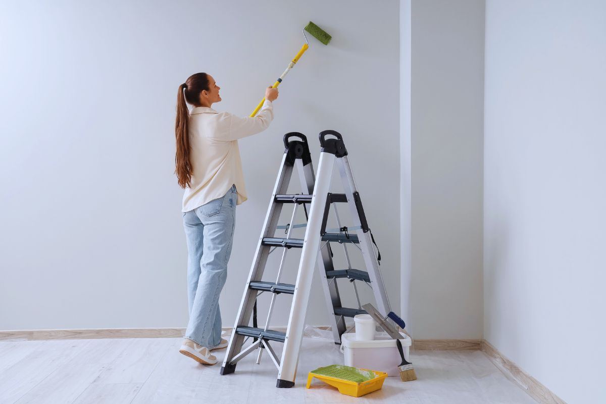 Donna che pittura una parete