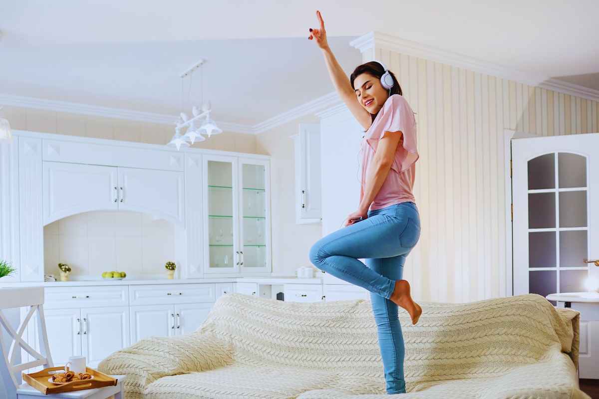 Ragazza che balla sul divano di casa