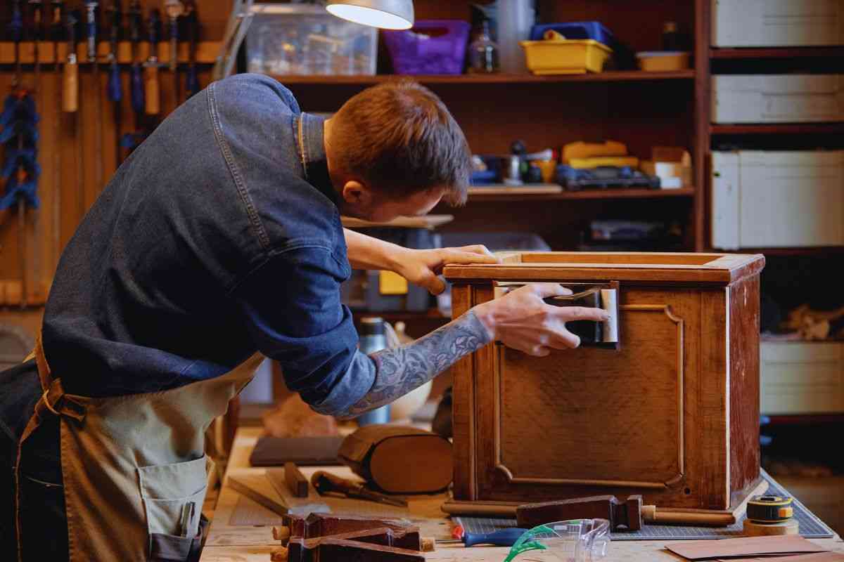 Artigiano che leviga legno mobile