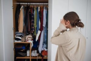 donna sopraffatta dal poco spazio nell'armadio