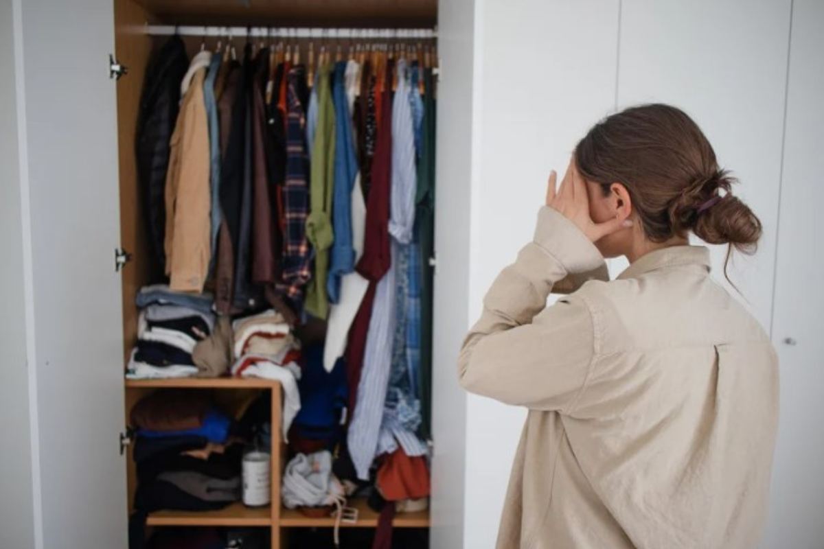 donna sopraffatta dal poco spazio nell'armadio 