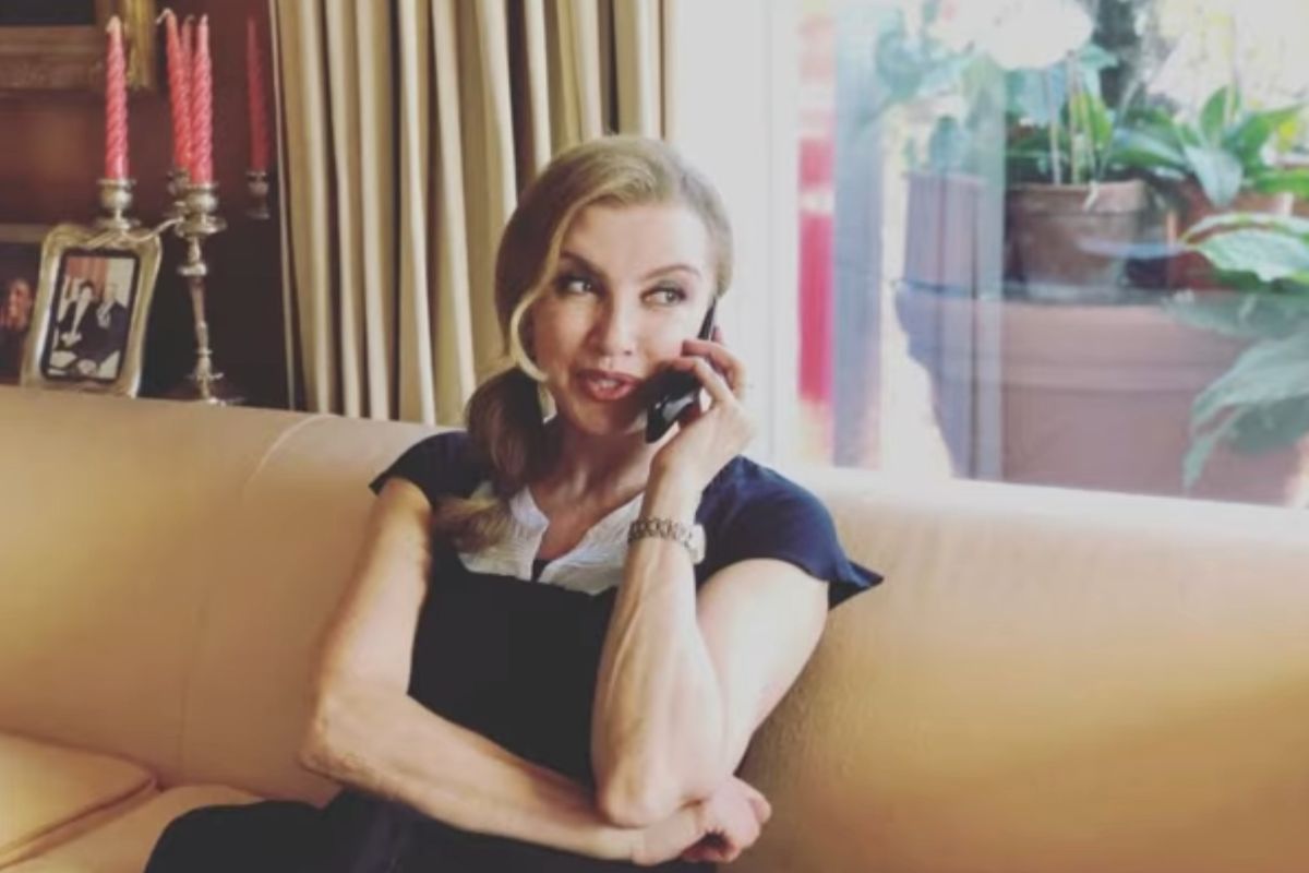 Milly Carlucci che parla al telefono dal divano di casa