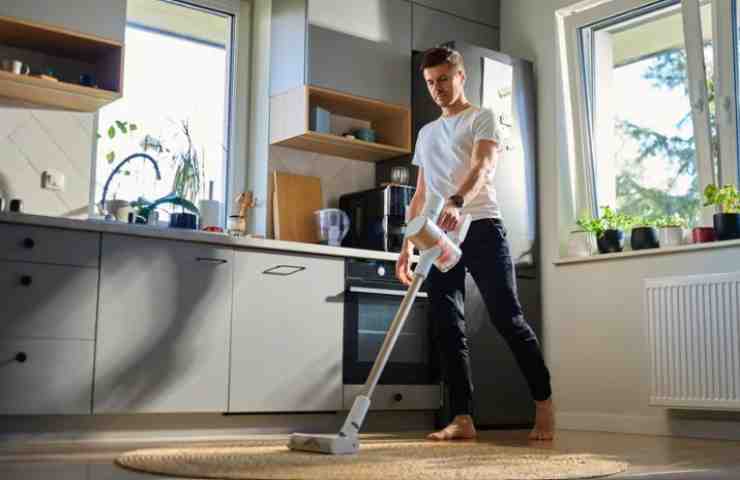 uomo passa l'aspirapolvere