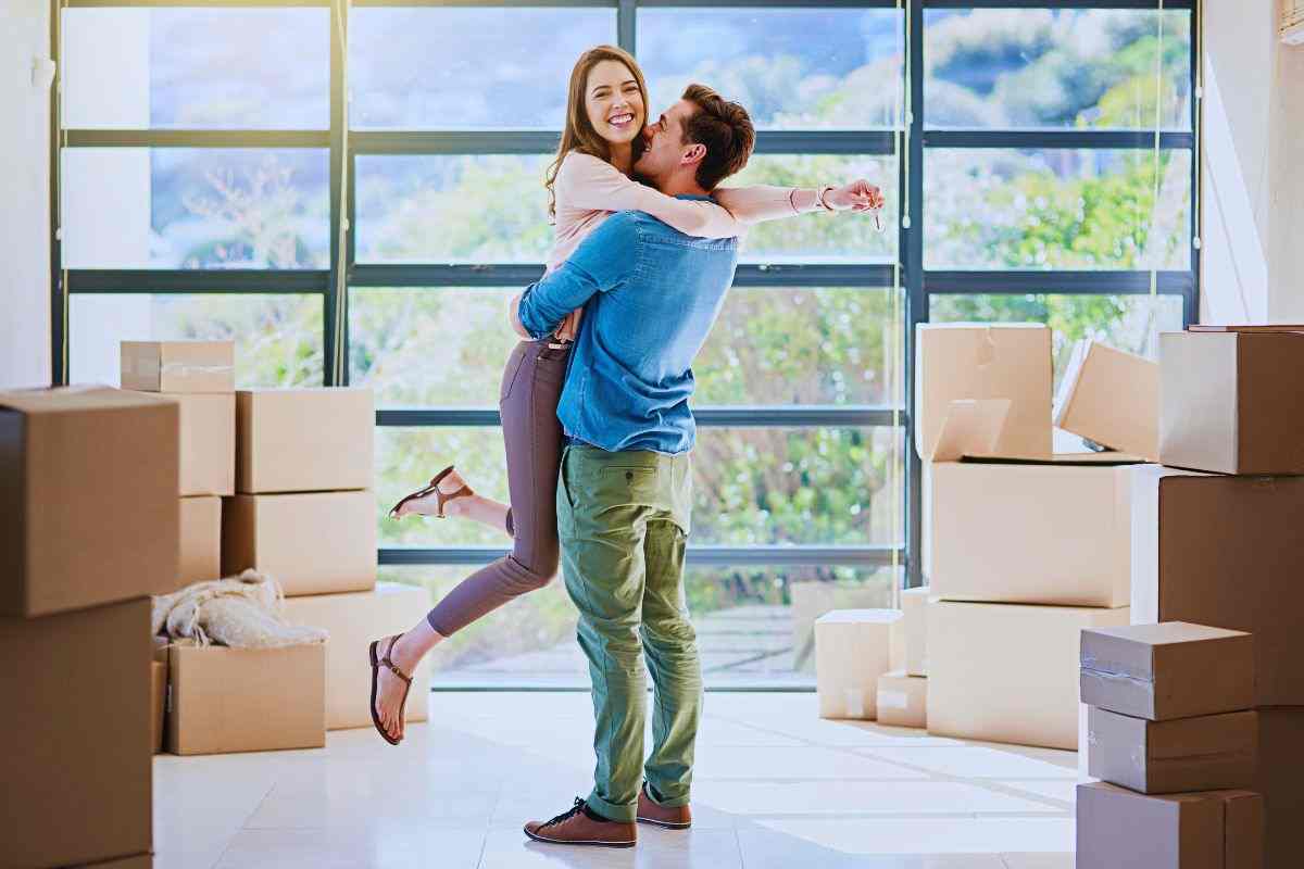 Giovane coppia che si abbraccia in mezzo a scatoloni