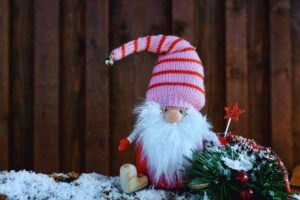 Gnomo natalizio poggiato su parete di legno