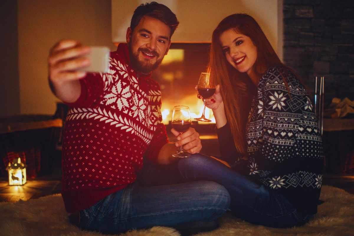 Coppia che si scatta un selfie davanti al camino acceso