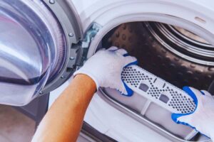 Uomo che smonta filtro lavatrice