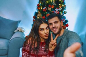 Coppia che si scatta un selfie davanti all'albero di Natale