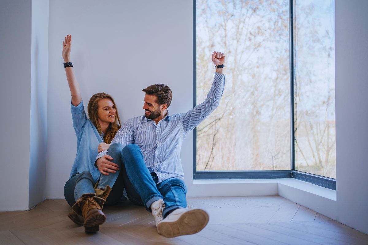 Coppia seduta su pavimento che esulta