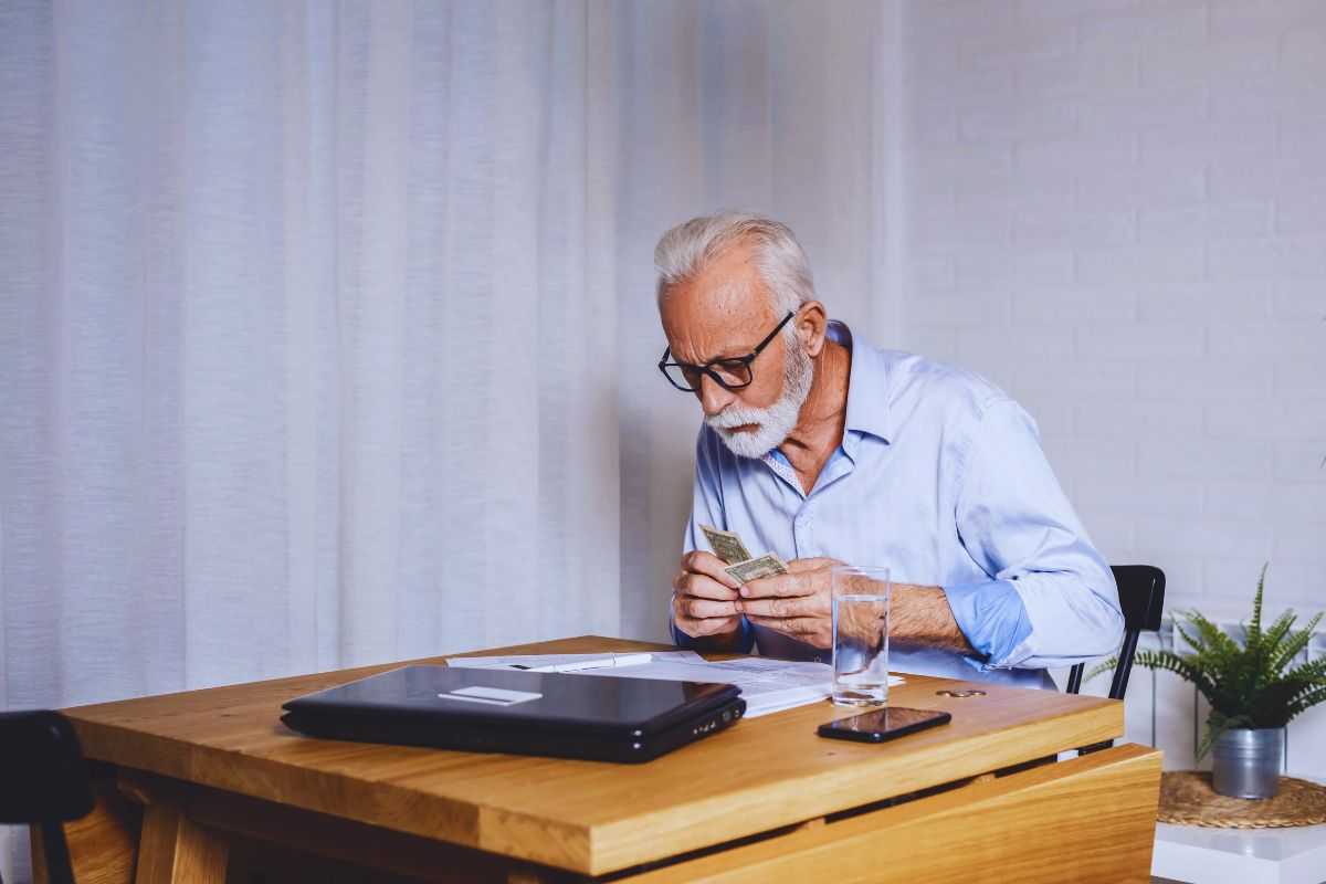 uomo anziano che conta denaro