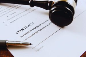 Martelletto da giudice poggiato sopra contratto di vendita