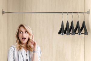 Donna che si fa venire un'idea e grucce appese nell'armadio