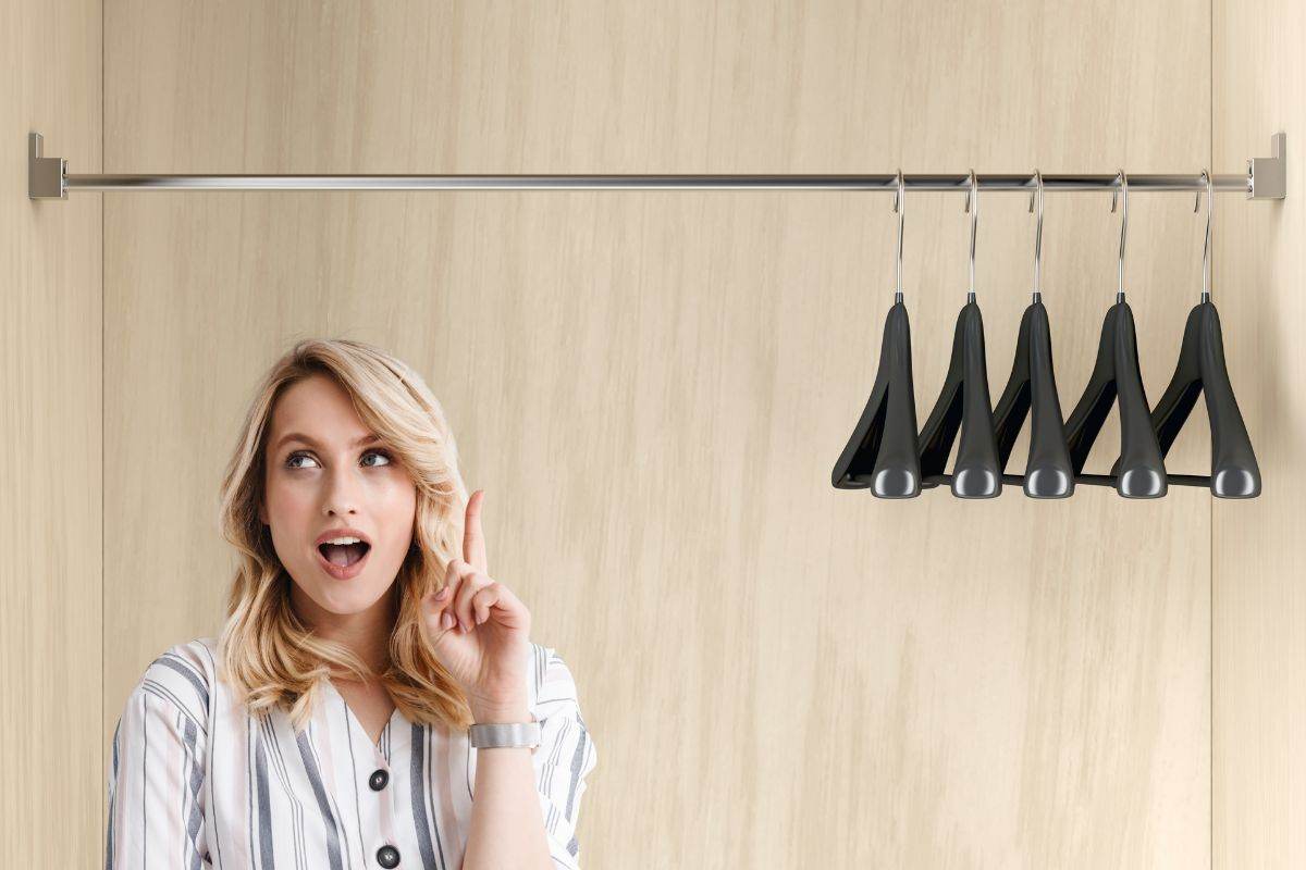 Donna che si fa venire un'idea e grucce appese nell'armadio