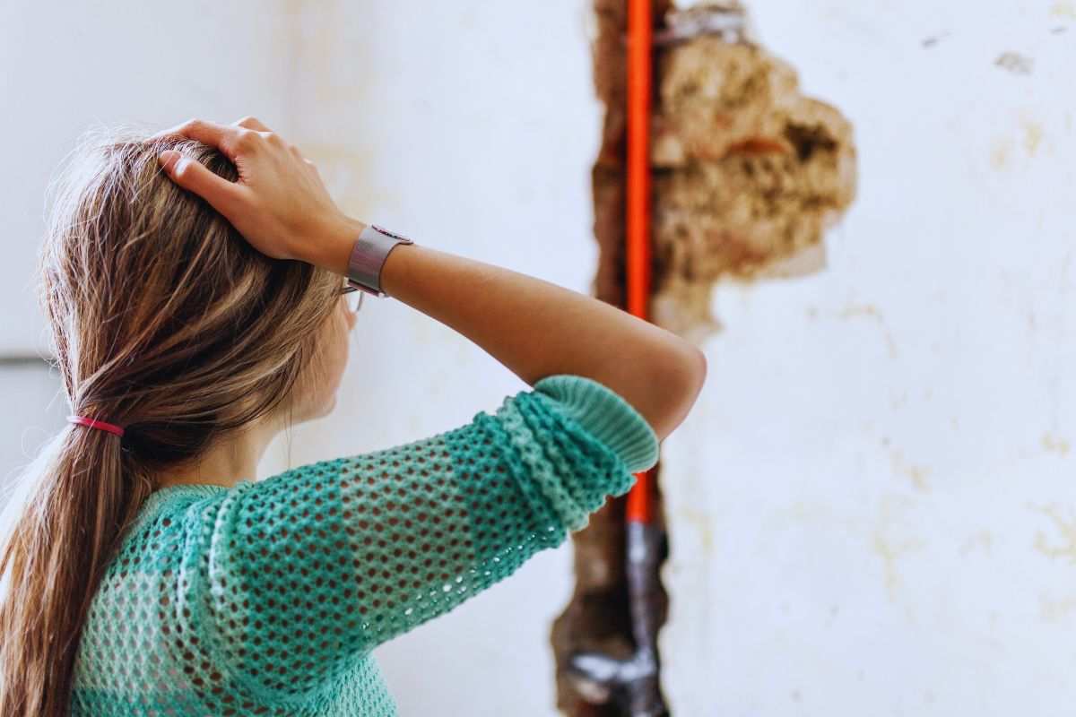 Donna preoccupata da enorme crepa su muro