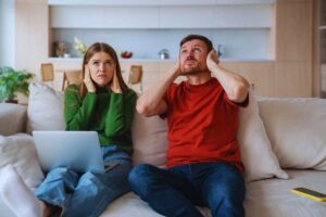 Coppia che si tappa le orecchie a causa del forte rumore