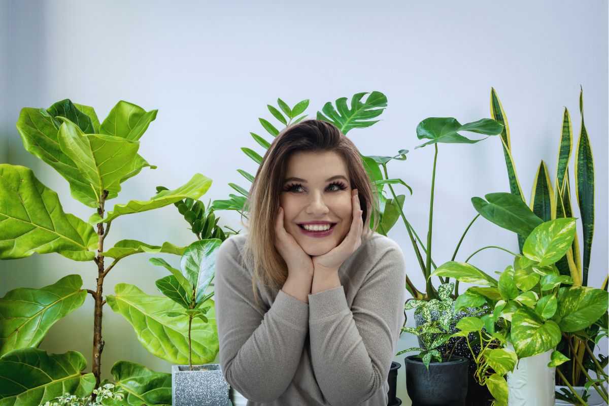 Donna sorridente in mezzo alle piante