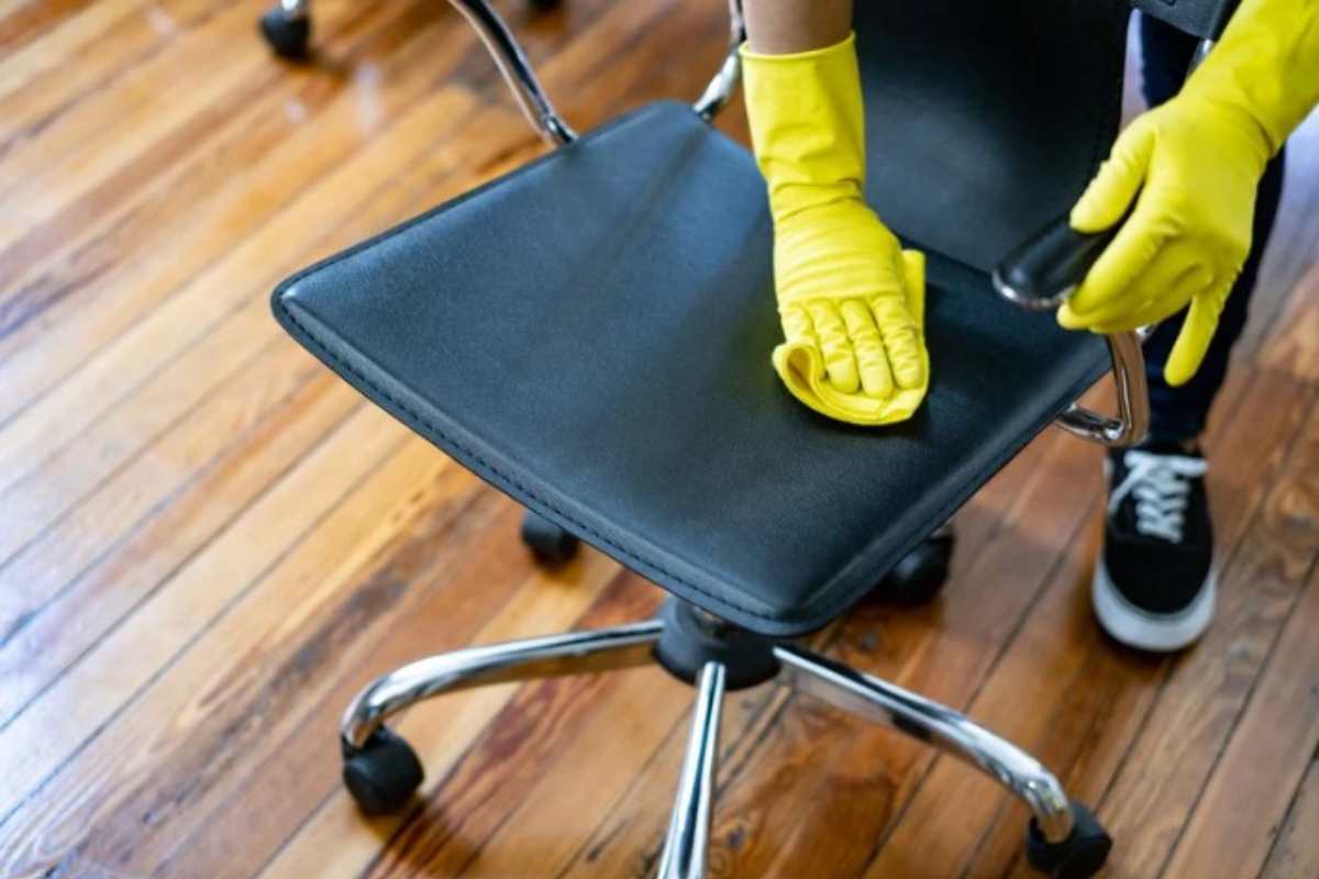 persona pulisce una sedia in tessuto 