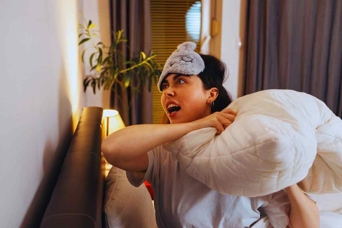 Donna infuriata che si appresta a colpire il muro per zittire i vicini