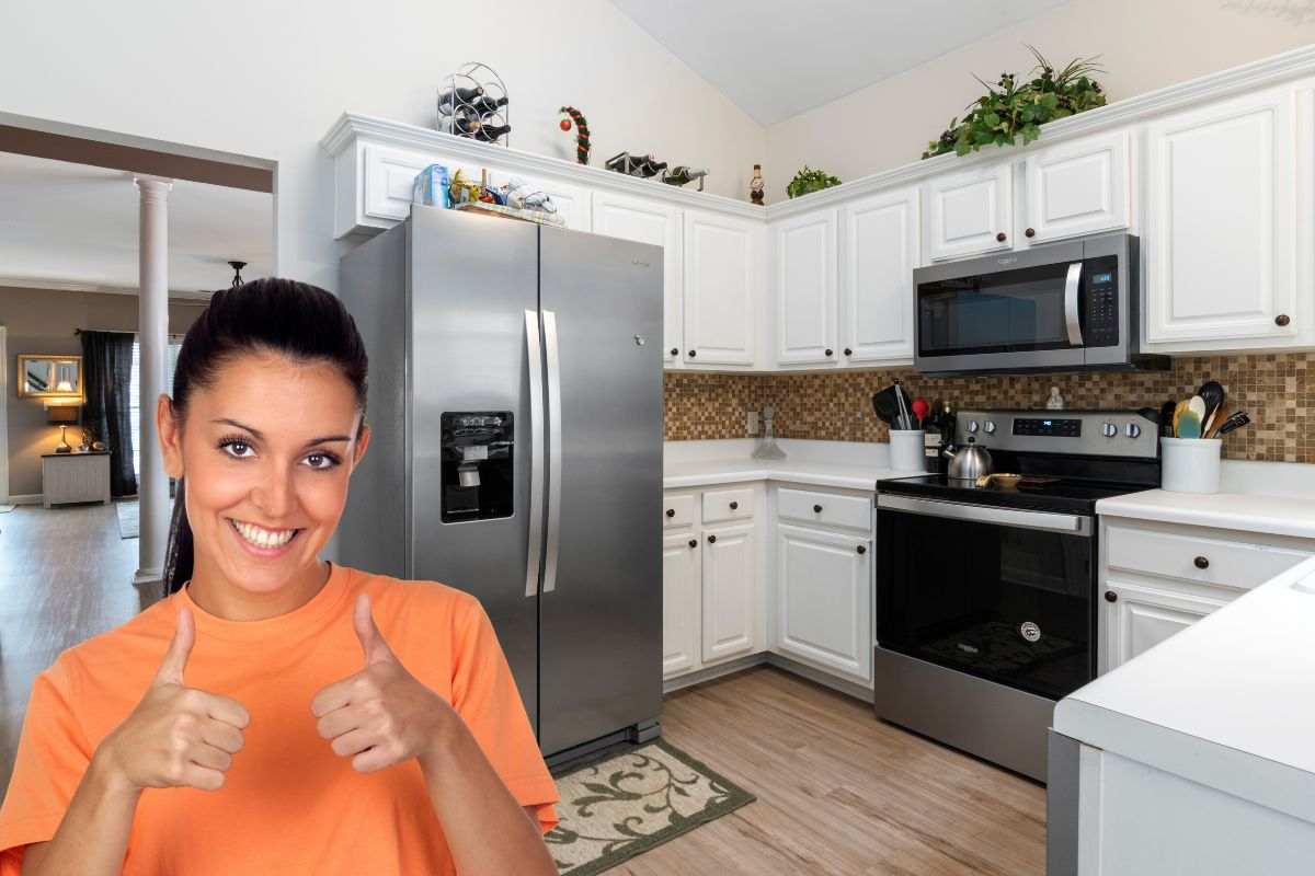 Donna che fa il gesto "Ok" accanto ad un frigorifero